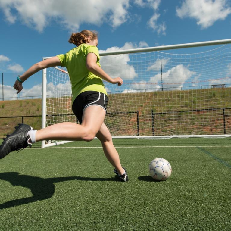 Jente i ferd med å skåre mål på fotballbanen